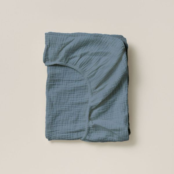 Cot fitted sheet in 120x60 size in denim blue made of organic muslin cotton from Petite Amélie 